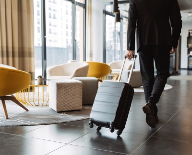 スーツケースを引いてホテルに入る男性